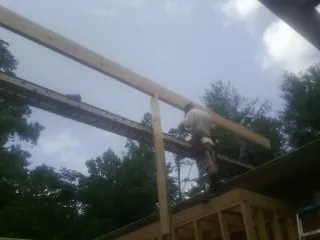 Carpenter setting a ridge beam over a new addition frame — Ice Dam Removal by Roofing Brothers in Crab Orchard